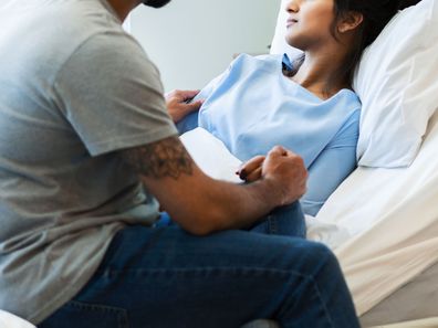 Woman in hospital bed with partner