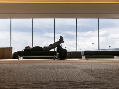 Man sleeping waiting for flight at the airport lounge