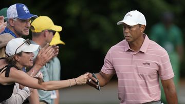 Tiger Woods greets a patron on the sixth hole.