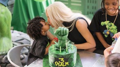 Kim Kardashian kissing son Psalm in front of third birthday cake.