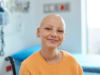 Bridgette smiles at the camera after losing her hair to chemotherapy and radiation.
