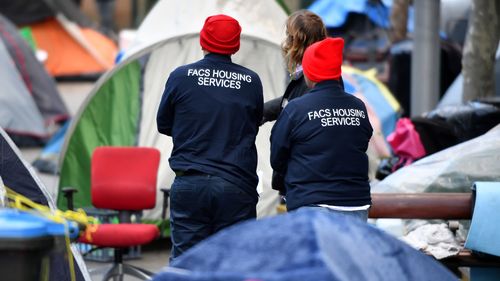 Officers from Family and Community Services inspect the tent city.