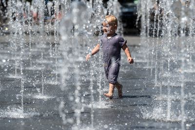 A child plays in a fountain in the city of North Rhine-Westphalia, Duisburg.