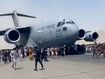 People so desperate to escape city they cling to outside of plane