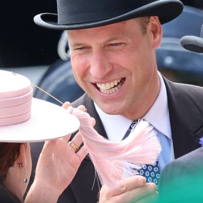 Prince William, Prince of Wales laughs as he plays with the tassle on Princess Eugenie of York's hat
