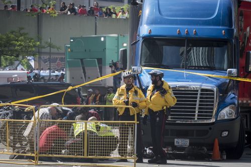 First responders attend to an injured person after shots were fired during the Toronto Raptors NBA basketball championship victory celebration near Nathan Phillips Square in Toronto (Tijana Martin/The Canadian Press via AP)