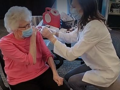 Ms Hawkins administers her grandmother's second dose of the COVID-19 vaccine.