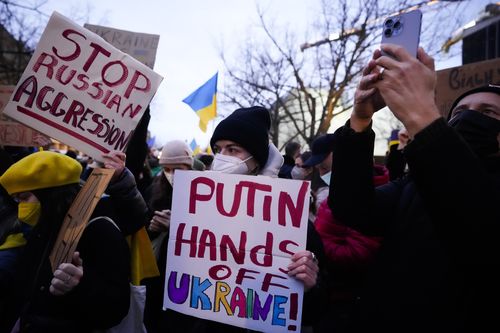 Women show posters in support of the Ukraine as they attends a demonstration along the street near the Russian embassy to protest against the escalation of the tension between Russia and Ukraine in Berlin, Germany, Tuesday, Feb. 22, 2022. (AP Photo/Markus Schreiber)