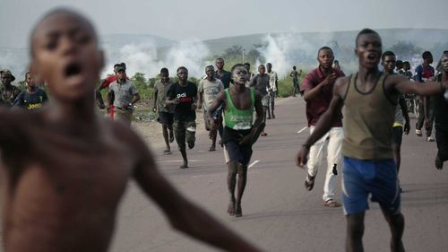 Supporters of opposition candidate Martin Fayulu run from tear gas fired by police in Nsele, 50kms east of Kinshasa, Democratic Republic of the Congo yesterday.