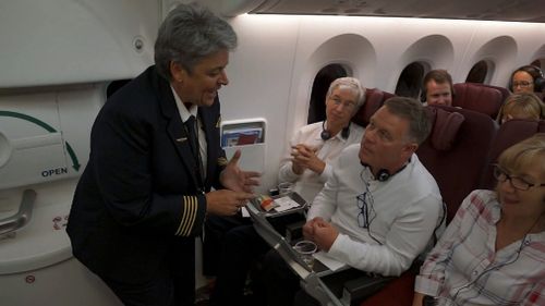 A Qantas staff member speaks with a passenger. (9NEWS)