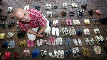 Tony Kevin, author of &quot;A Certain Maritime Incident&quot;, sits amongst the 146 pairs of shoes, with each pair representing a child that drowned when the ship Siev-X sank on its way to Christmas Island.