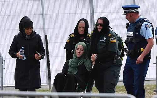 A mourner is attended to after the funeral of father and son, Khaled and Hamza Mustafa(AAP Image/Mick Tsikas).