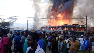 People gather as shops burn in Wamena