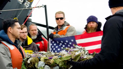Project Recover, crew members prepare to place a wreath over the wreckage of the stern of the destroyer USS Abner Read.
