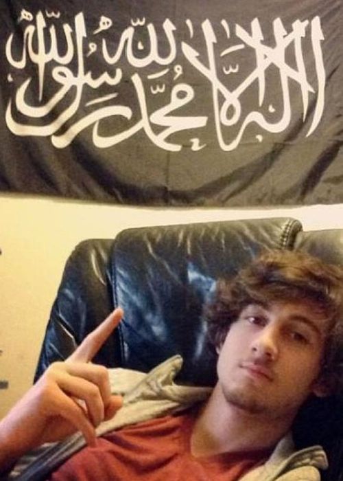 Dzhokhar Tsarnaev points to the ISIL flag hung in his bedroom.