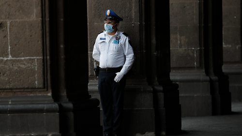 A police officer wearing protective gear against the spread of the new coronavirus, stands guard outside the mayor's office, in the historic center of Mexico City, Wednesday, April 1, 2020.