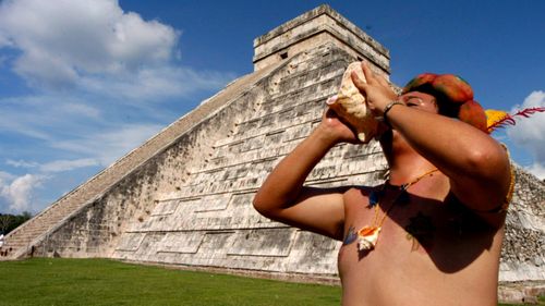 A Mayan descendant plays a shell to invoke the god 'Kukulcan' in front of the Chichen Itza pyramid in Mexico. (Photo: AP).