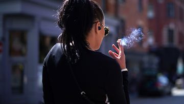 A woman smokes a cigarette.
