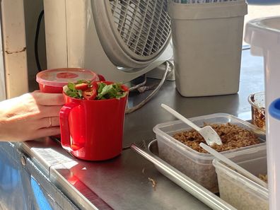 Two reusable plastic mugs filled with laksa in Darwin