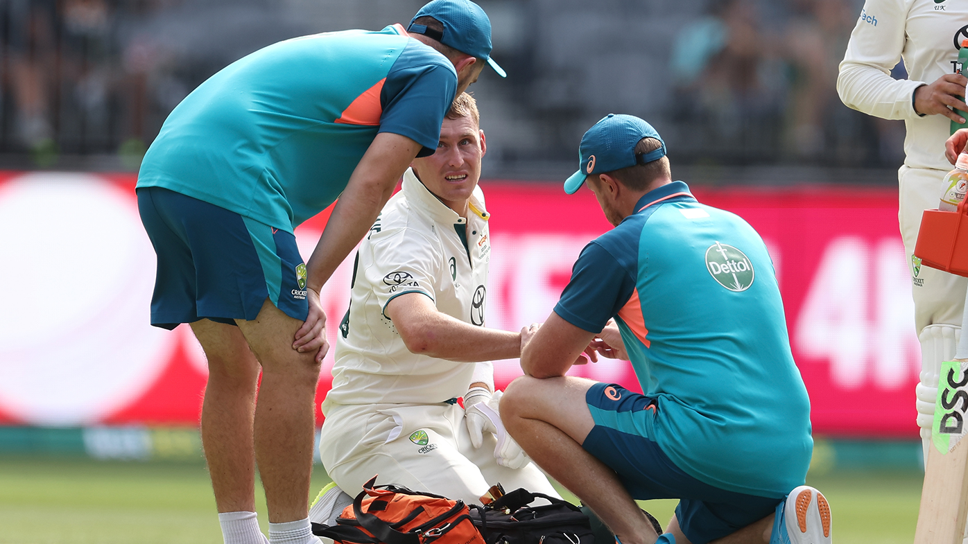 Marnus Labuschagne receives attention on the field after being struck by a delivery from Khurram Shahzad during day three of the first Test match between Australia and Pakistan.