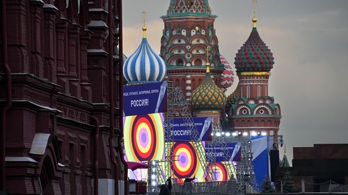 People make preparations for a concert at the Red Square, with constructions reading the words ''Donetsk, Luhansk, Zaporizhzhia, Kherson, Russia'', and the St. Basil's Cathedral and Lenin Mausoleum on the background, in Moscow, Russia, Thursday, Sept. 29, 2022. The Kremlin said that Russian President Vladimir Putin and the leaders of the four regions of Ukraine that held a referendum on joining Russia will attend a ceremony to sign documents on the regions' incorporation into Russia, which will 