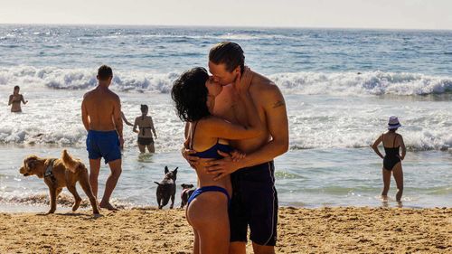 A couple kiss at MacKenzies Beach in Sydney.