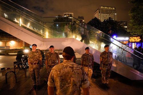 British servicemen observe a "National moment of reflection" in honour of the late Queen Elizabeth II, the day before her funeral, in London, Sunday, Sept. 18, 2022. 