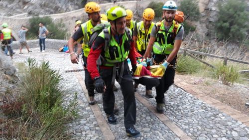 Survivors are brought out the flooded gorge by rescue teams.