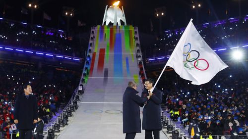 IOC President Thomas Bach handed off the Olympic flag to the mayor of Beijing, Chen Jining. (AAP)