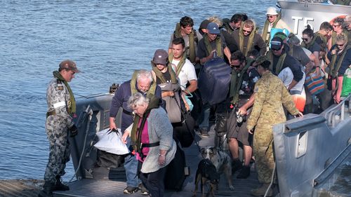 Military landing craft arrives with CFA members and evacuees in Hastings.