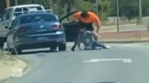 An unknown driver in a high-visibility shirt can be seen dragging the cab driver out of his car, throwing him to the ground and then punching him multiple times.