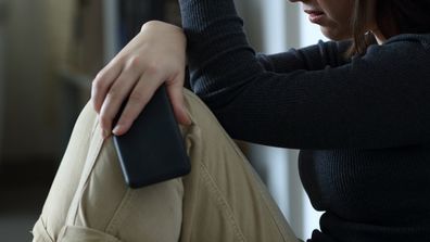 Sad woman holding phone