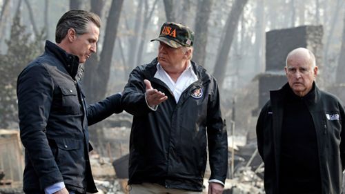 President Donald Trump talks with Governor Gavin Newsom, left, as California Governor Jerry Brown listens during a visit to a neighborhood impacted by the Camp wildfire in Paradise, California.