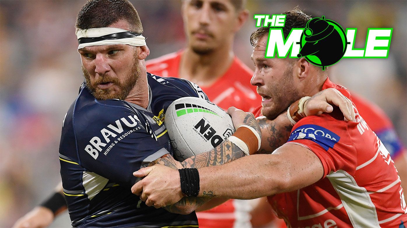 Cowboys star Josh McGuire is tackled by Dragons forward Trent Merrin.