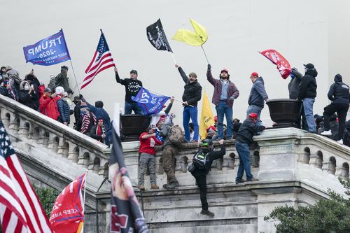 FILE - Rioters wave flags on the West Front of the U.S. Capitol