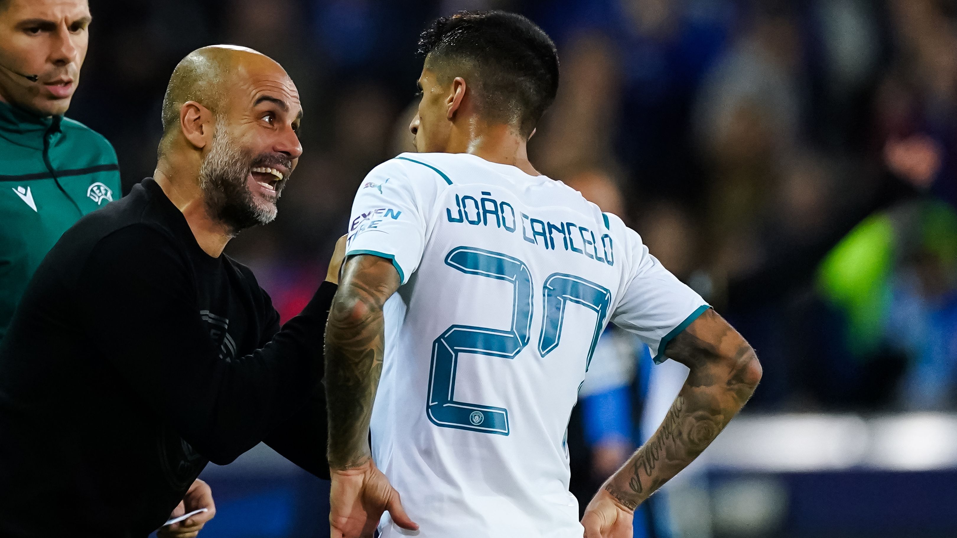 Pep Guardiola of Manchester City in discussion with Joao Cancelo.