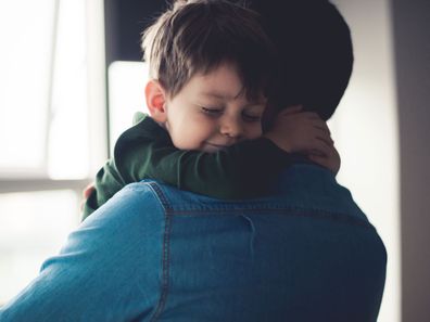 Young boy hugging his father