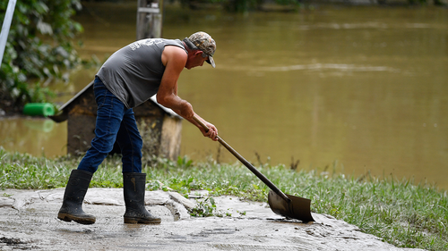 Junior Bowling shovels mud and silt from receded floodwaters in Jackson, Kentucky, Friday, July 29, 2022. 