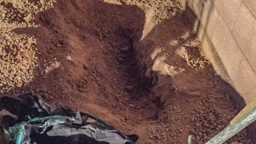 The hole dug to plant a tree in a backyard in Phoenix, Arizona.
