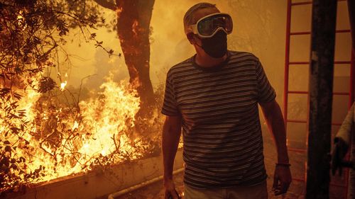 Will Adams watches as flames from the Palisades Fire close in on his property in the Pacific Palisades.