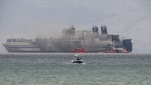 Smoke rises from the Italian-flagged Euroferry Olympia, which is on fire for third day, in the Ionian sea near the Greek island of Corfu, on Sunday, Feb. 20, 2022. Some 280 passengers and crew were rescued Friday well the number of people listed as missing was increased from 11 to 12 after authorities discovered that one person on the Italy-bound vessel was not on the passenger list and was believed to be a migrant. (AP Photo/Petros Giannakouris)