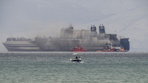 Smoke rises from the Italian-flagged Euroferry Olympia, which is on fire for third day, in the Ionian sea near the Greek island of Corfu, on Sunday, Feb. 20, 2022.  Some 280 passengers and crew were rescued Friday well the number of people listed as missing was increased from 11 to 12 after authorities discovered that one person on the Italy-bound vessel was not on the passenger list and was believed to be a migrant. (AP Photo/Petros Giannakouris)