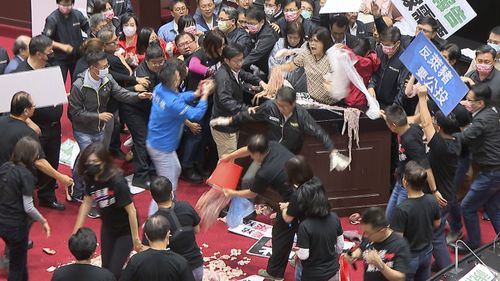 In this image made from video, lawmakers fight during a parliament session in Taipei, Taiwan, Friday, Nov. 27, 2020.