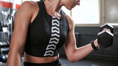 Woman lifting dumbbell in a gym