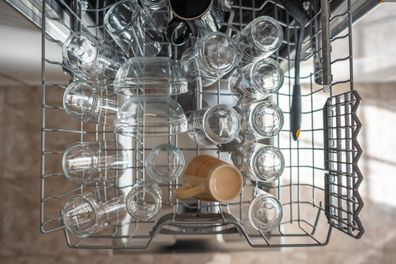 Plates and cutlery in the dishwasher ready to be placed in the cupboards