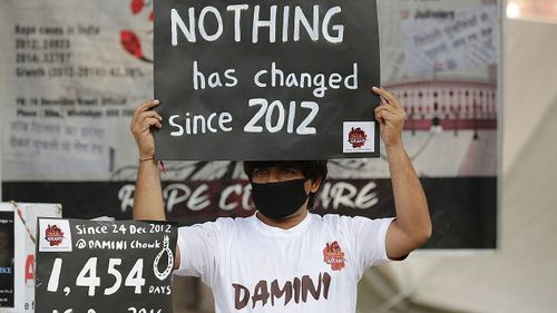 An Indian activist holds placards as he takes part in a protest to mark fourth anniversary of the Delhi gang rape crime, at Jantar Mantar in New Delhi, India. (AAP)