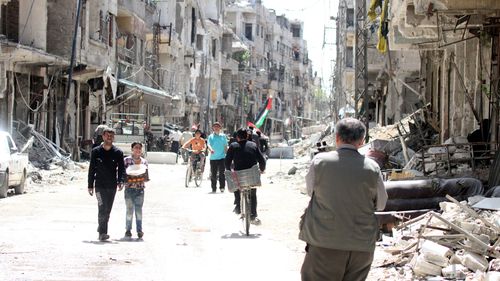 People walk the streets in Zamalka, Eastern Ghouta, in the countryside of Damascus on April 8. (AAP)