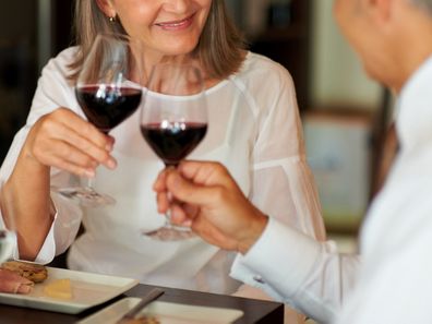 Elderly woman toasting wine with her husband at a smart restaurant