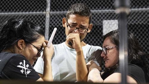 El Paso Wal-Mart employees weep at a vigil after the massacre in their store.