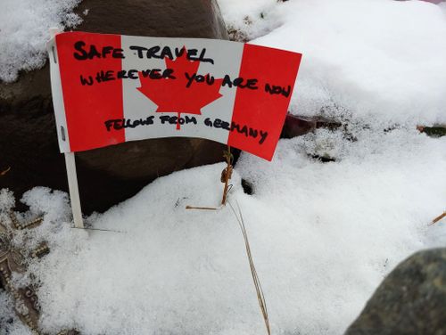 A handwritten note from a traveller sits in fresh snow at the memorial on Alaska Highway, in rugged northern British Columbia.